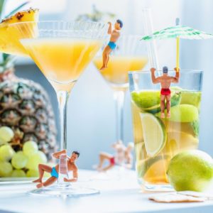 Marque-verres en forme d'hommes en maillot de bain posés sur le bord de verres à cocktails