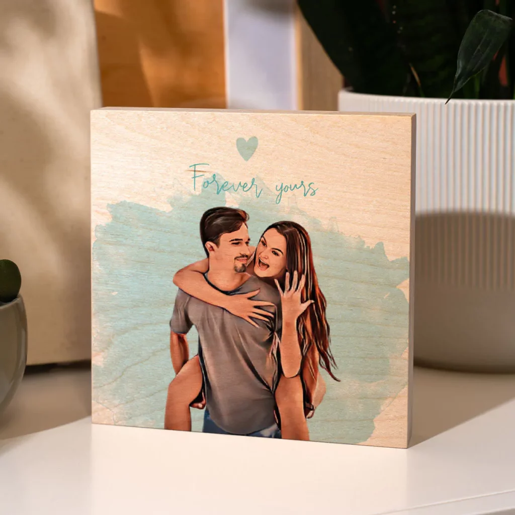 Sur cette image, des mains tiennent une photo personnalisée d'un couple, dans le style cartoon et imprimée sur du bois.