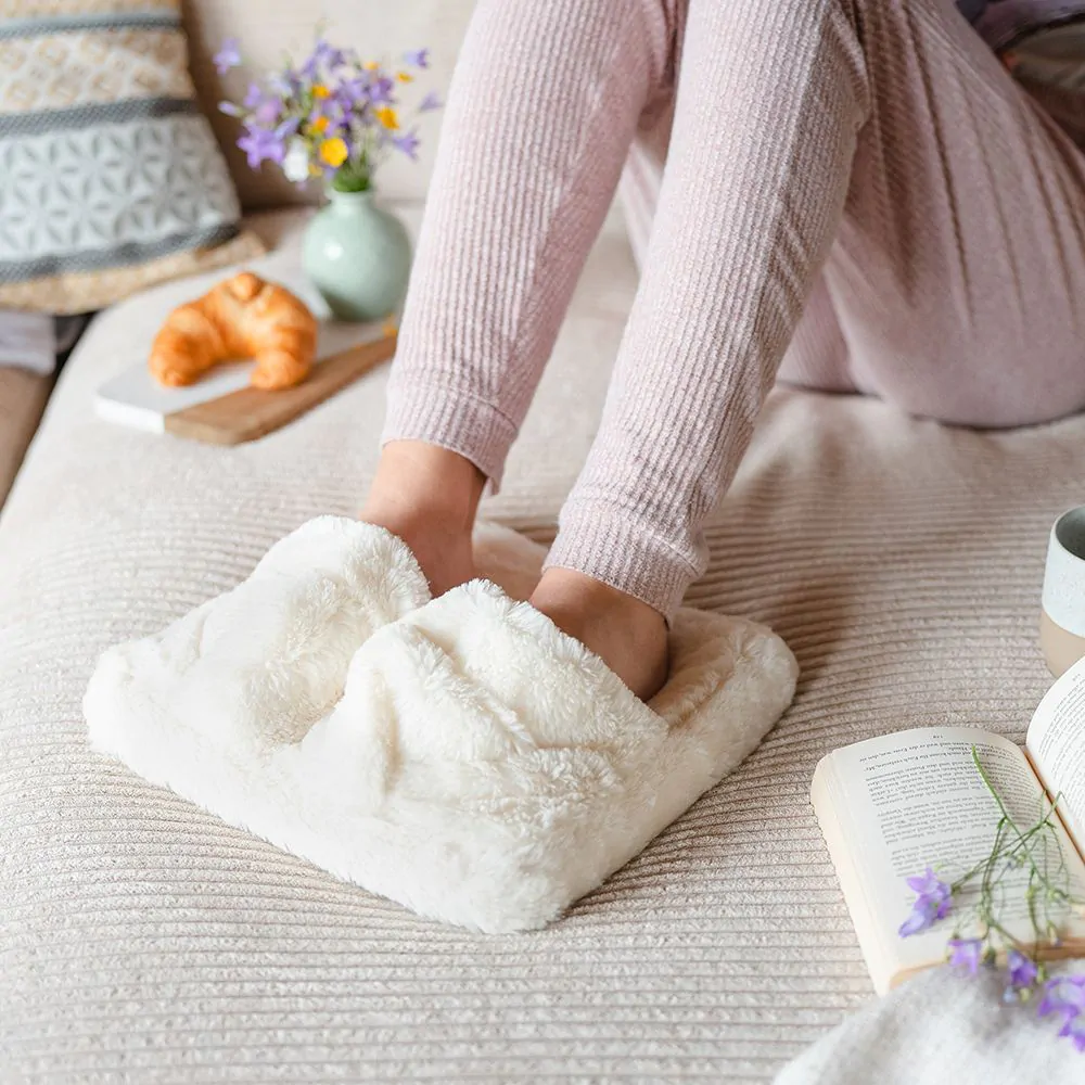 Ceci est une image des pieds d'une femme dans un appareil de massage pour pieds, en peluche blanche