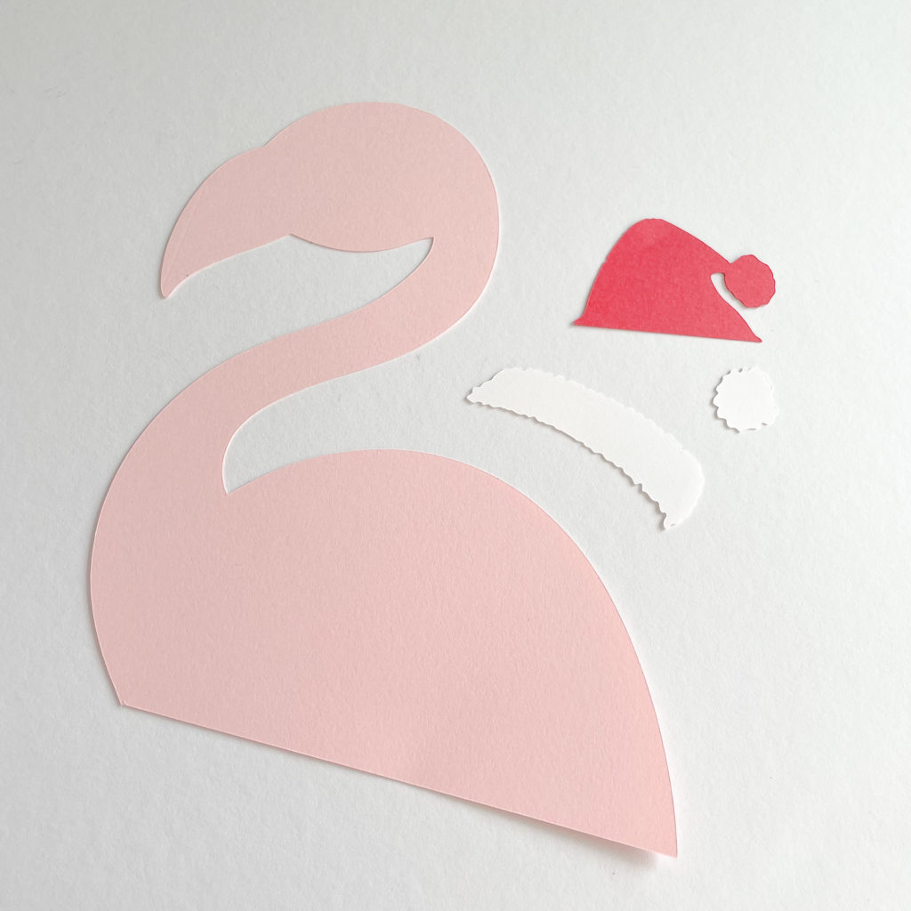 Silhouette d'un flamant rose en papier avec un bonnet de noel