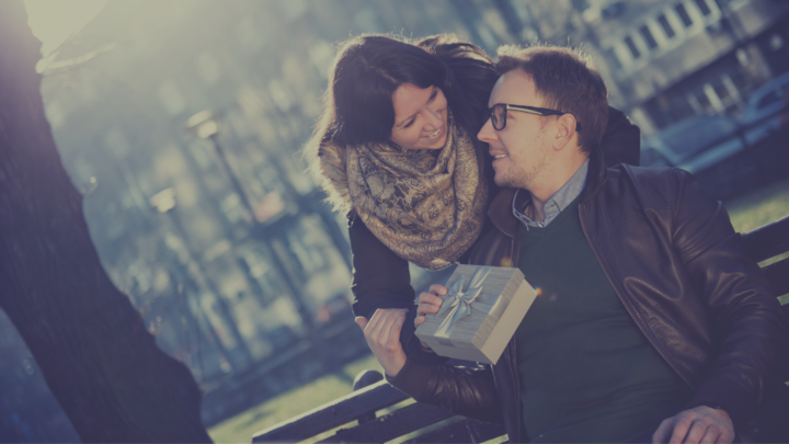 Femme qui offre un cadeau à un homme sur un banc