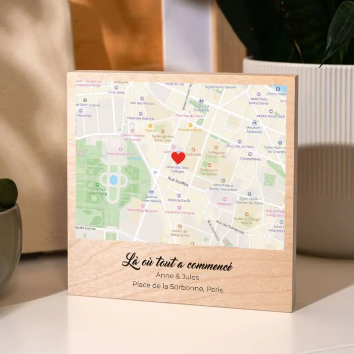 Tableau en bois avec un plan de ville imprimé et un coeur rouge indiquant "Là où tout a commencé"