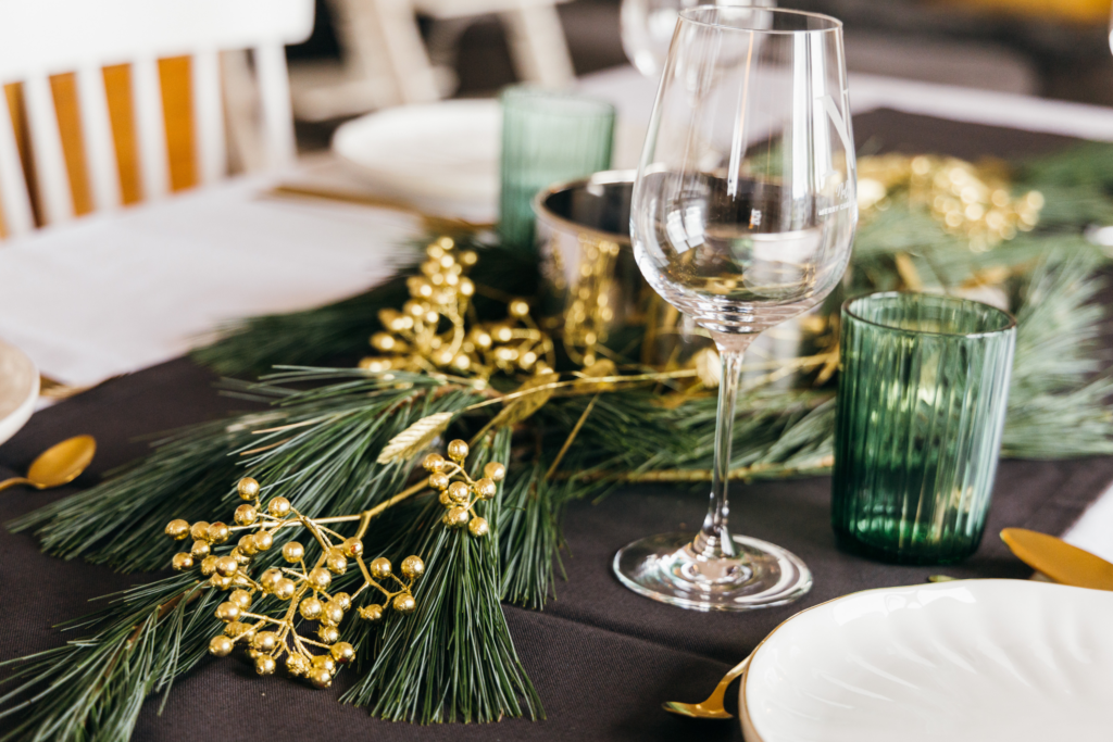 Verre à pied sur une table avec éléments de décoration végétaux