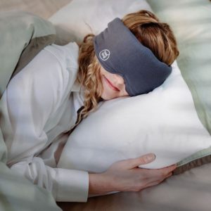femme dormant la tête sur l'oreiller avec un masque de sommeil