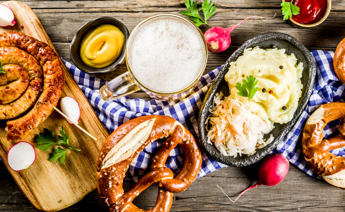 Table remplie de bière, bretzel, purée et décoration d'Oktoberfest