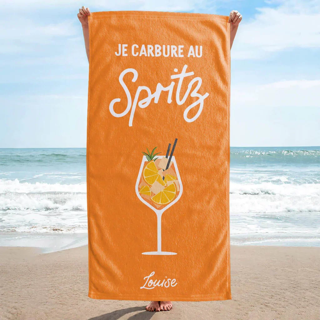 Serviette de bain orange avec marqué "Je carbure au spritz" et un dessin d'aperol et un prénom